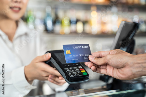 Customer using credit card for payment at cashier in cafe restaurant. photo