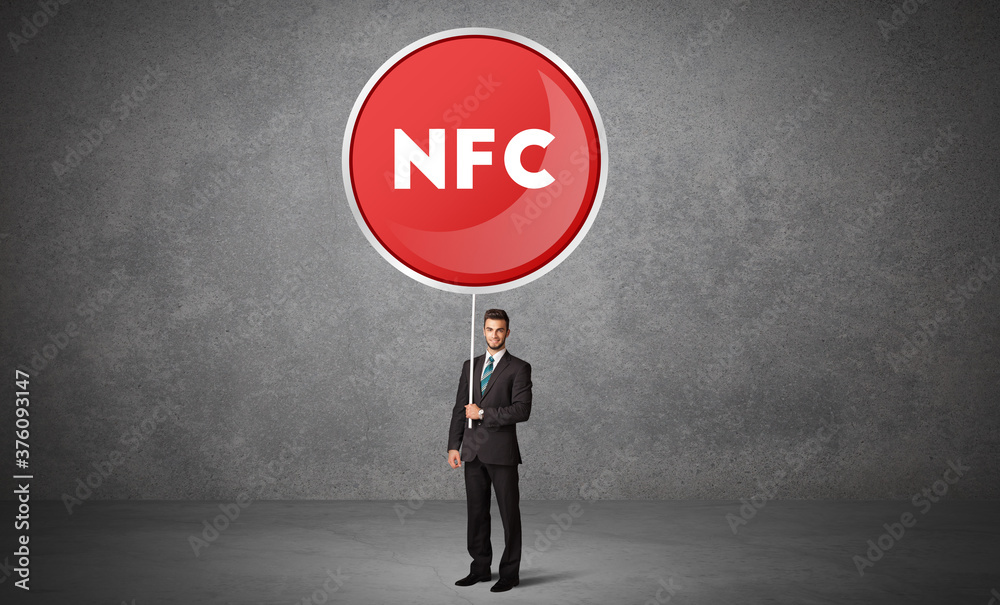 Young business person holdig traffic sign with NFC abbreviation, technology solution concept Young business person holdig traffic sign with NFC abbreviation, technology solution concept