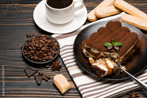 portion of Classic tiramisu dessert and savoiardi cookies on wooden background