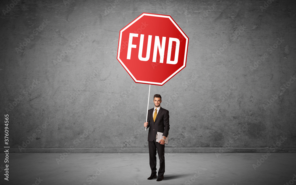 Young business person holding road sign with FUND inscription, new rules concept