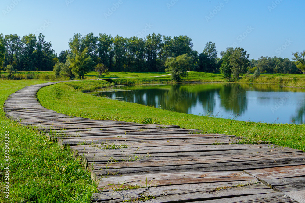 A beautiful view along wooden boardwalk along the shores of a calm lake
