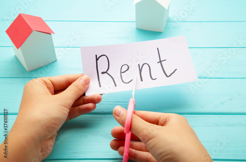 The word Rent written on paper and cut in half with a pair of scissors