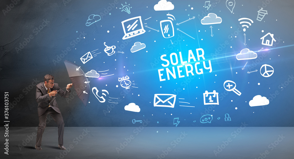 Businessman defending with umbrella from SOLAR ENERGY inscription, modern technology concept Businessman defending with umbrella from SOLAR ENERGY inscription, modern technology concept