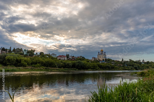 Russia, the city of Yelets, view of the Sosna river and the Cathedral of the ascension of the Lord under a cloudy sunset sky.