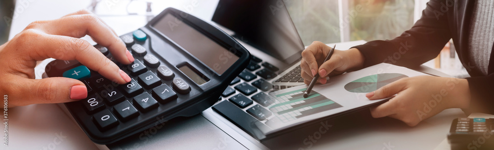 Business people use tablets and hold credit cards as an online shopping concept With a calculator and a book placed on the table Business people use tablets and hold credit cards as an online shopping concept With a calculator and a book placed on the table