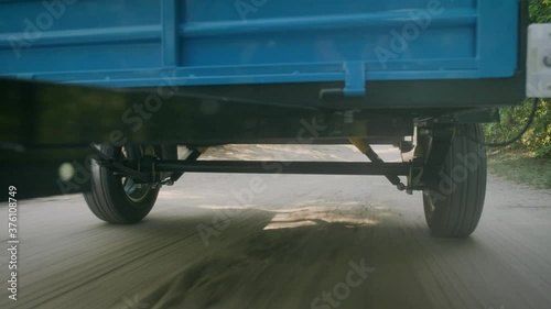 A small cargo trailer for a car on the move. View of the cross member of the wheelbase from below and extremely close.