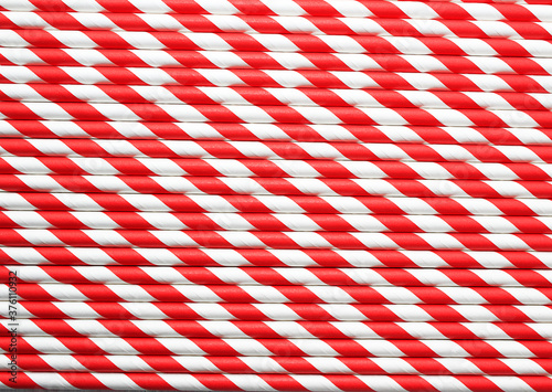 Abstract background of red and white colored paper striped cocktail straws.