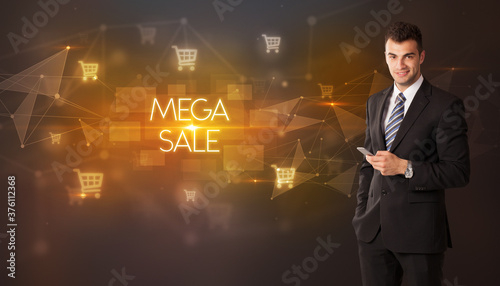 Businessman with shopping cart icons and MEGA SALE inscription  online shopping concept