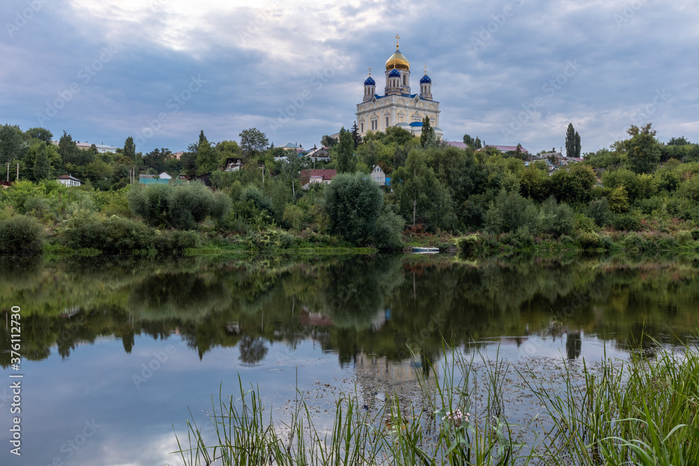 Russia, the city of Yelets, view of the high Bank of the Sosna river and the Cathedral of the ascension of the Lord under a cloudy sunset sky.