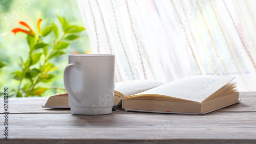 Mug of coffee near an open book