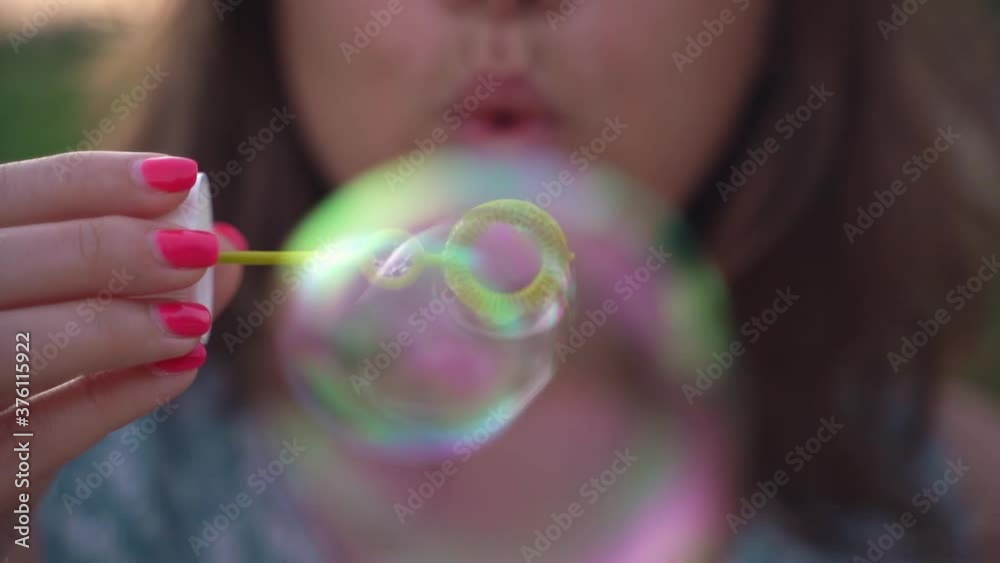 Woman with pink nails blowing soap bubbles Face close up Slow motion Woman with pink nails blowing soap bubbles Face close up Slow motion
