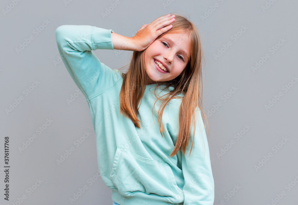 Just happy. Young smiling exited woman in casual wear holding hand on head and shouting while standing against gray studio background. Cheerful crazy girl with open mouth posing to camera Just happy. Young smiling exited woman in casual wear holding hand on head and shouting while standing against gray studio background. Cheerful crazy girl with open mouth posing to camera