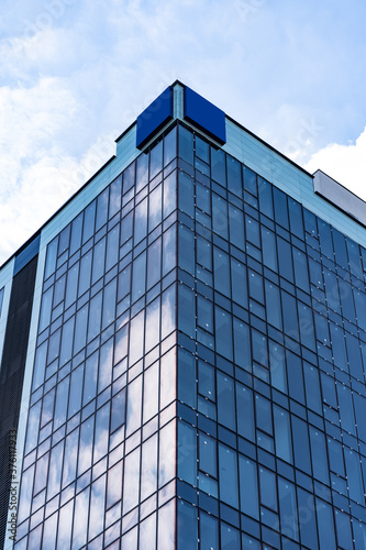 Modern Glass Building Architecture with blue sky and clouds