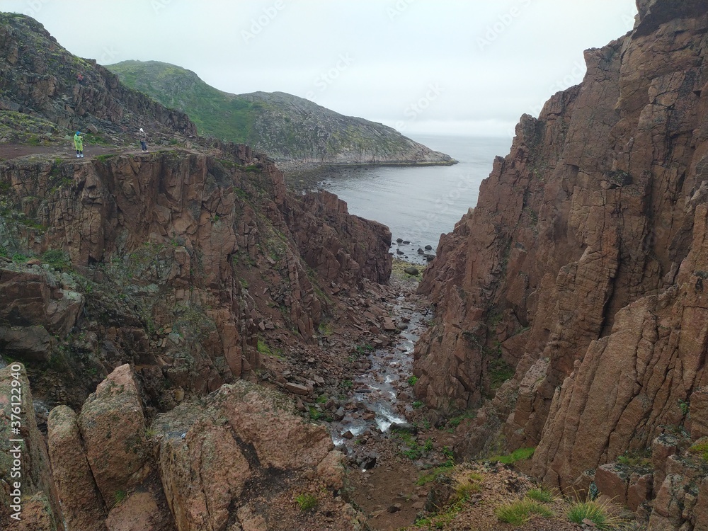 High cliffs and waterfalls on the coast of the Barents sea Arctic ocean