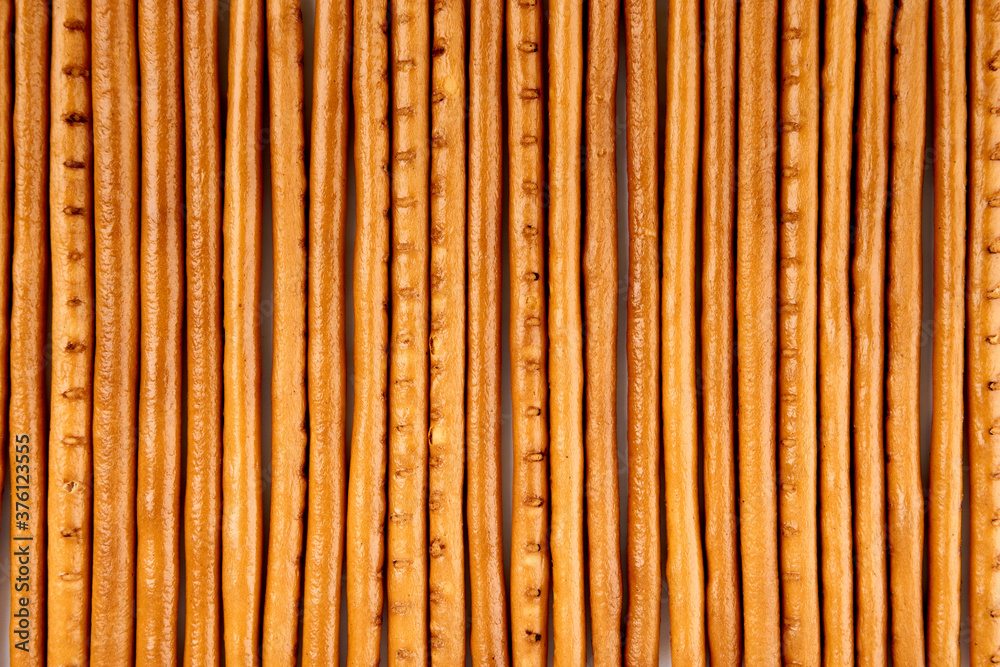Creative layout made of crackers sticks on the white background. Food concept. Edible snack dry sticks with salt on white background. Straws, sticks crackers. Creative layout made of crackers sticks on the white background. Food concept. Edible snack dry sticks with salt on white background. Straws, sticks crackers.