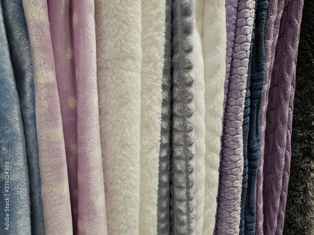 Blankets of different colors are hanging on the shop window Blankets of different colors are hanging on the shop window