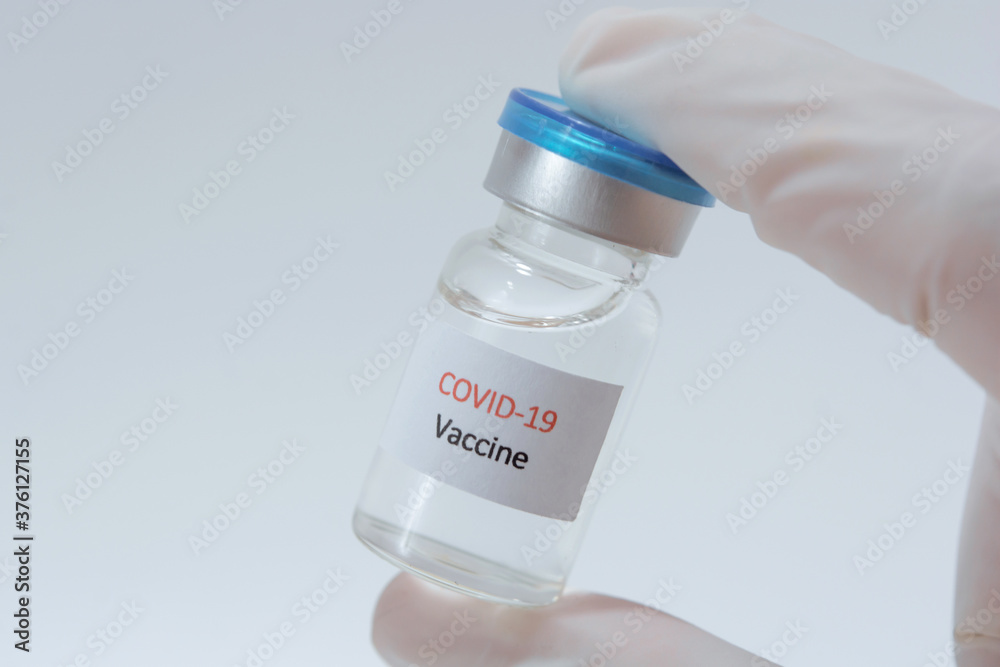 Vaccine COVID-19 (Coronavirus) glass bottle in medical doctor hand