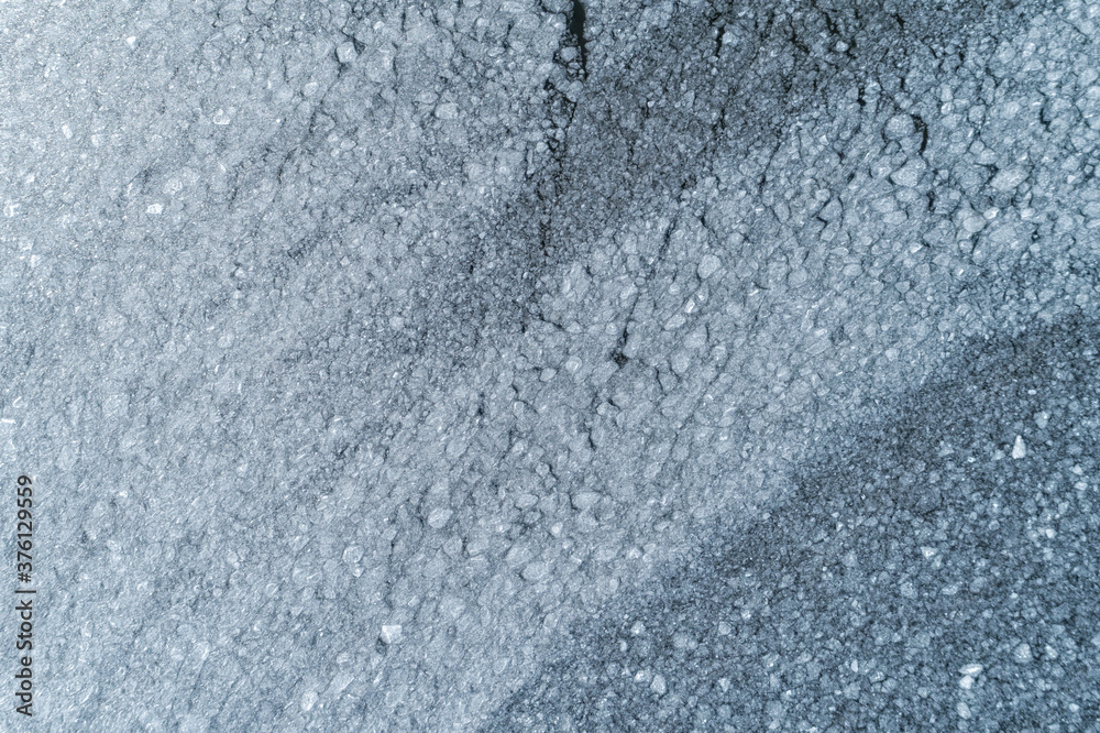 Obraz premium Water surface covered with ice texture. Aerial view of a frozen sea.