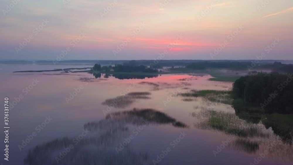 The lake is from above, the drone flies over the silhouettes of the beautiful islands and, illuminated by purple morning sunlight. Aerial flight over the lakes during the fantastic sunrise. 4K The lake is from above, the drone flies over the silhouettes of the beautiful islands and, illuminated by purple morning sunlight. Aerial flight over the lakes during the fantastic sunrise. 4K