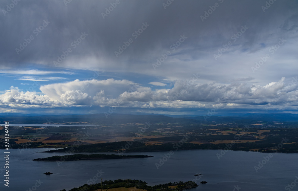 Panoramic view of a rural landscape with heavy dark rain storm clouds moving in.