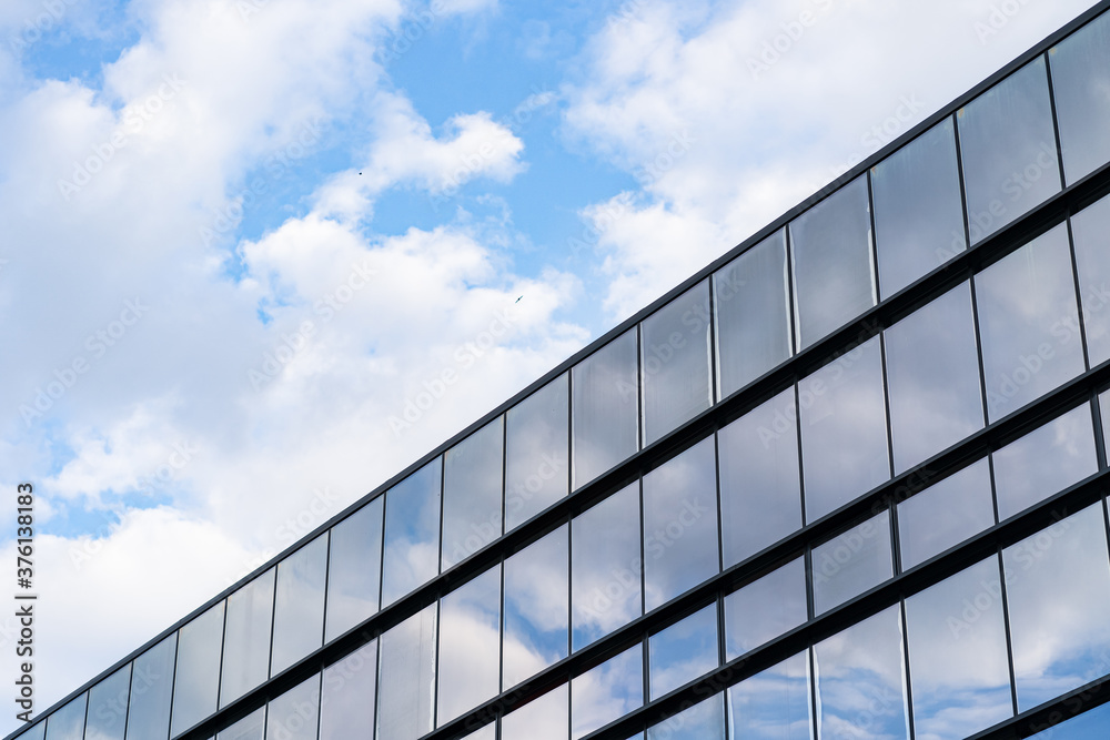 Modern Glass Building Architecture with blue sky and clouds Modern Glass Building Architecture with blue sky and clouds