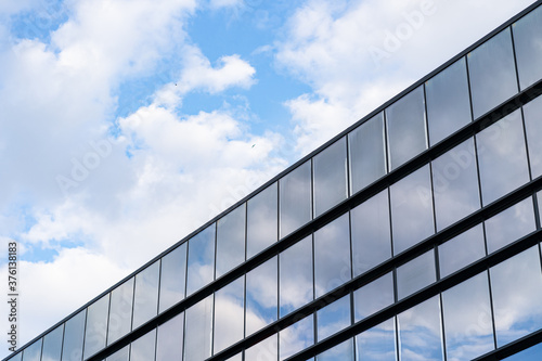 Modern Glass Building Architecture with blue sky and clouds