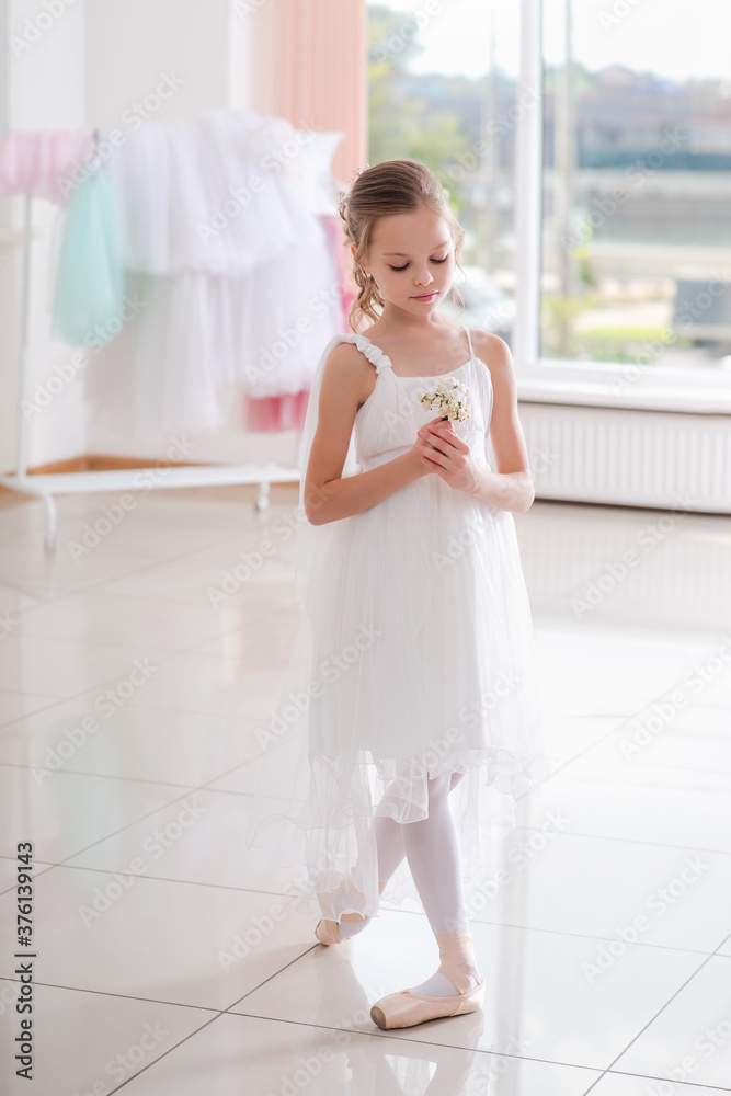 Cute little ballerina in white dress and pointe shoes dreams about ballet dances. Cute little ballerina in white dress and pointe shoes dreams about ballet dances.