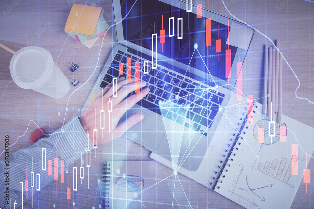 Double exposure of man's hands typing over computer keyboard and forex graph hologram drawing. Top view. Financial markets concept. Double exposure of man's hands typing over computer keyboard and forex graph hologram drawing. Top view. Financial markets concept.
