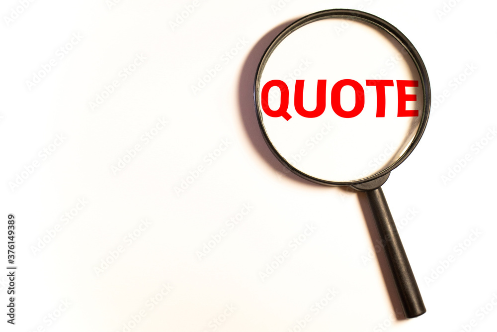 Magnifying glass on papers with word quote of quote written on it. Magnifying glass on papers with word quote of quote written on it.