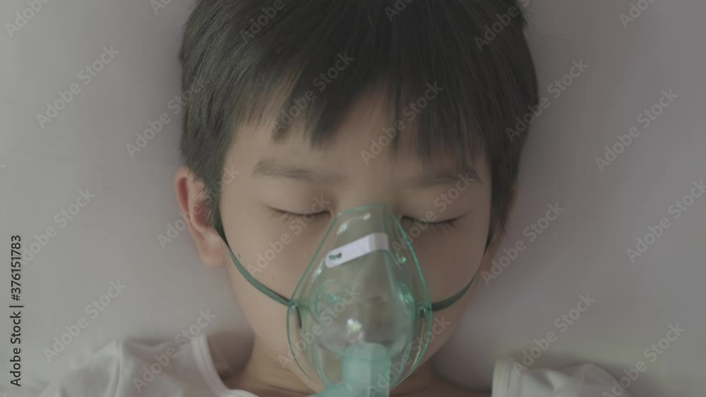 4k Top view Young asian boy with oxygen mask sleep on a bed