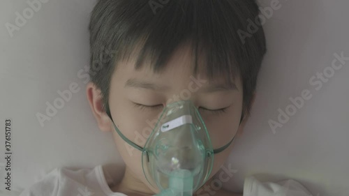 4k Top view Young asian boy with oxygen mask sleep on a bed