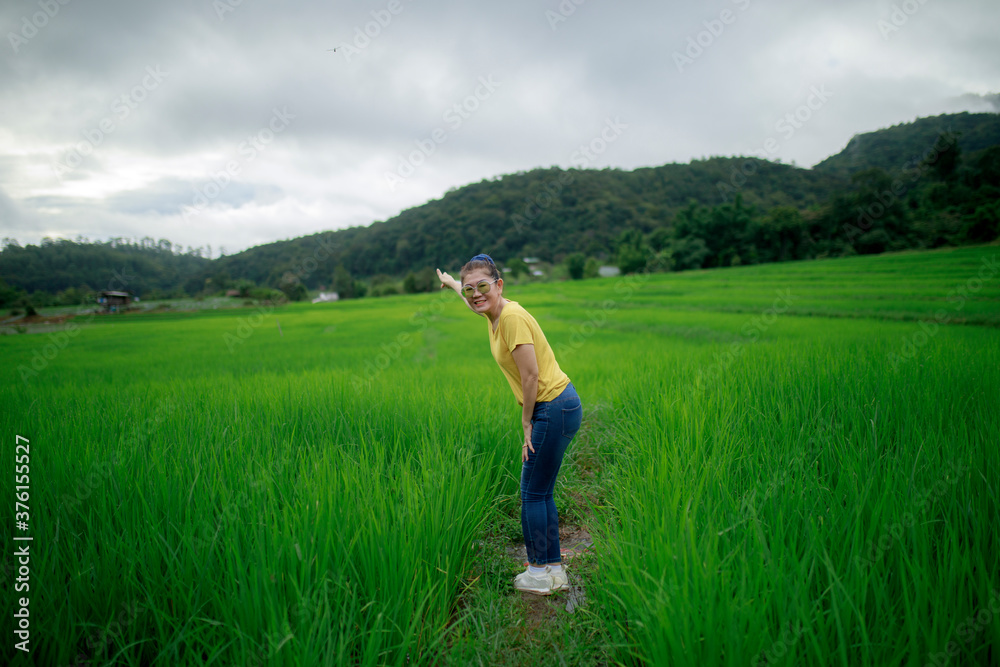 asina woman standing with relaxing in green rice field asina woman standing with relaxing in green rice field