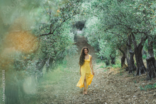 Fototapeta Young happy smiling woman walking in olive tree garden