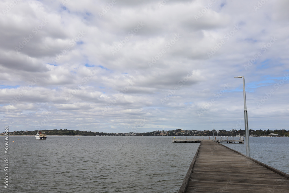 Freshwater Bay jetty, over the Swan River, a cloudy day with hints of blue sky above.