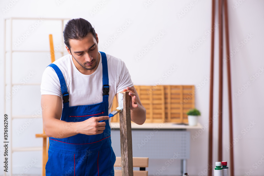 Young male contractor working in workshop