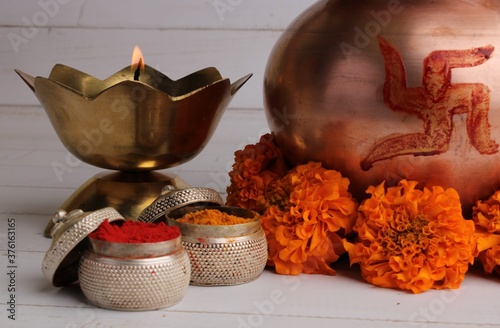 copper kalash with coconut and mango leaf with haldi kumkum floral decoration. essential in hindu puja. photo