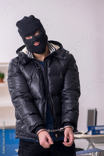 Young male burglar in the office