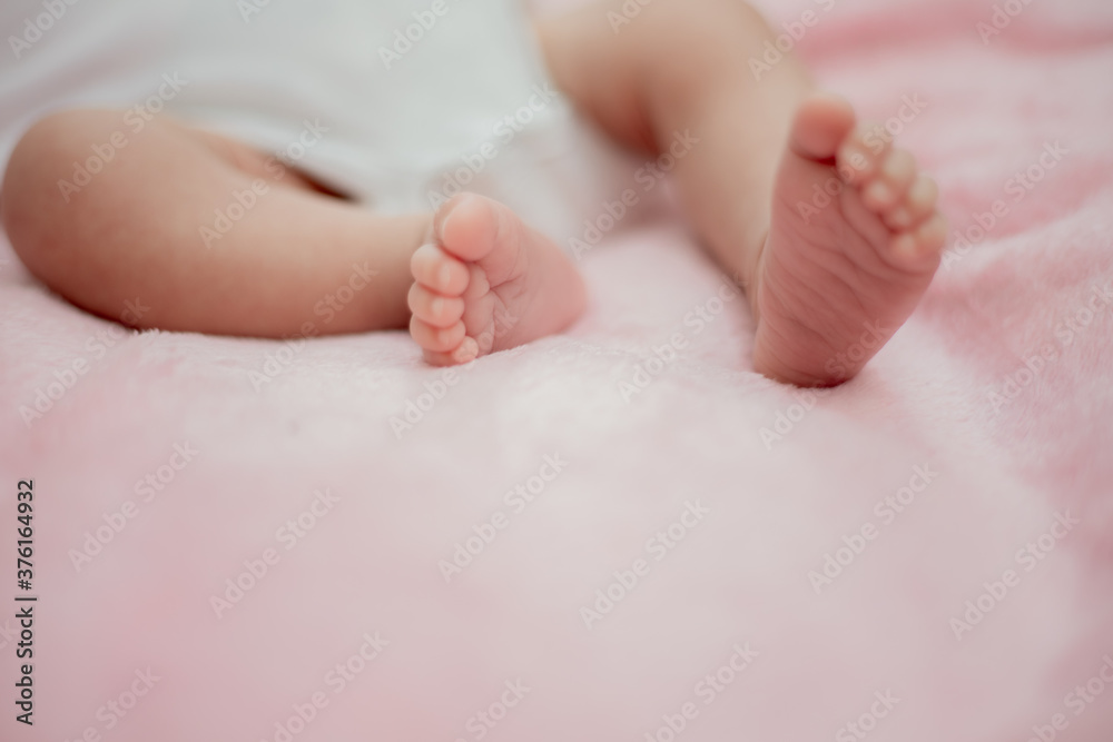 baby feet in bed The little boy's feet are sleeping on the pink mattress