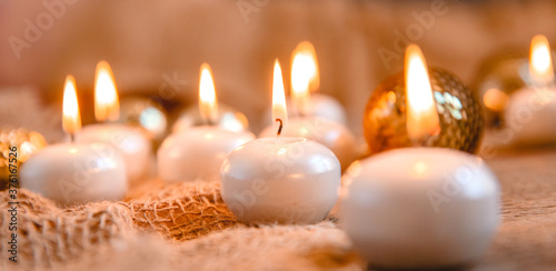 Lit candles  Christmas tree Golden baubles and burlap on a wooden background. New year s and Christmas concept