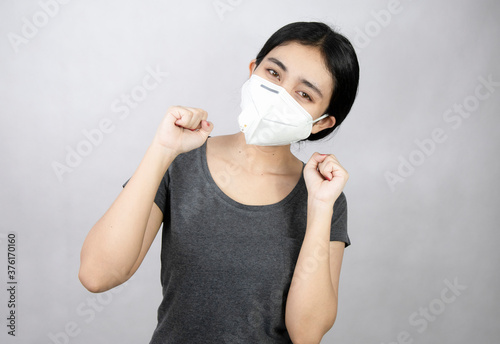 Young Asian women wear masks and express their confidence that the COVID-19, or coronavirus disease, will be gone.