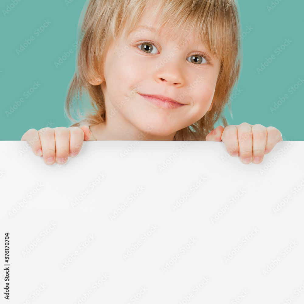 Cute smiling boy showing blank banner with space for text Cute smiling boy showing blank banner with space for text