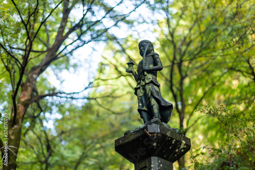 an isolated buddhism statue in forest on mount takao, tokyo, japan