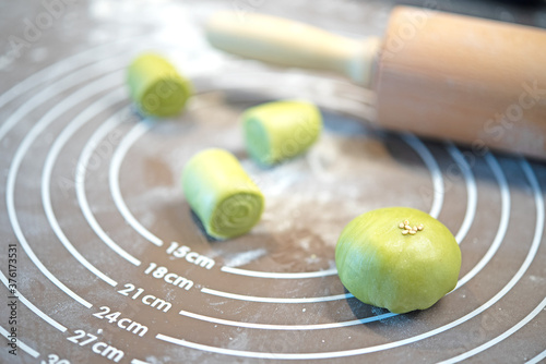Rolling pin, dough on silicone baking mat. Preparing to asian cookies