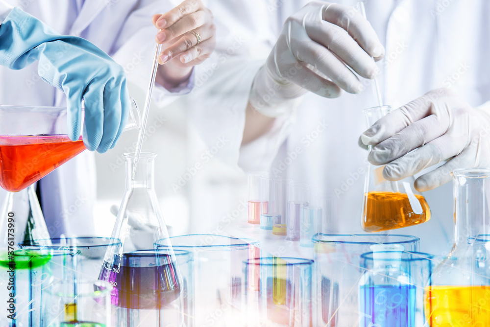 hand of scientist holding flask and pouring sample to test tube in chemical laboratory background, science laboratory research and development concept hand of scientist holding flask and pouring sample to test tube in chemical laboratory background, science laboratory research and development concept