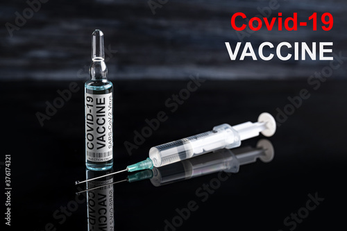 Covid-19 vaccine ampoule with syringe Coronavirus dark background photo