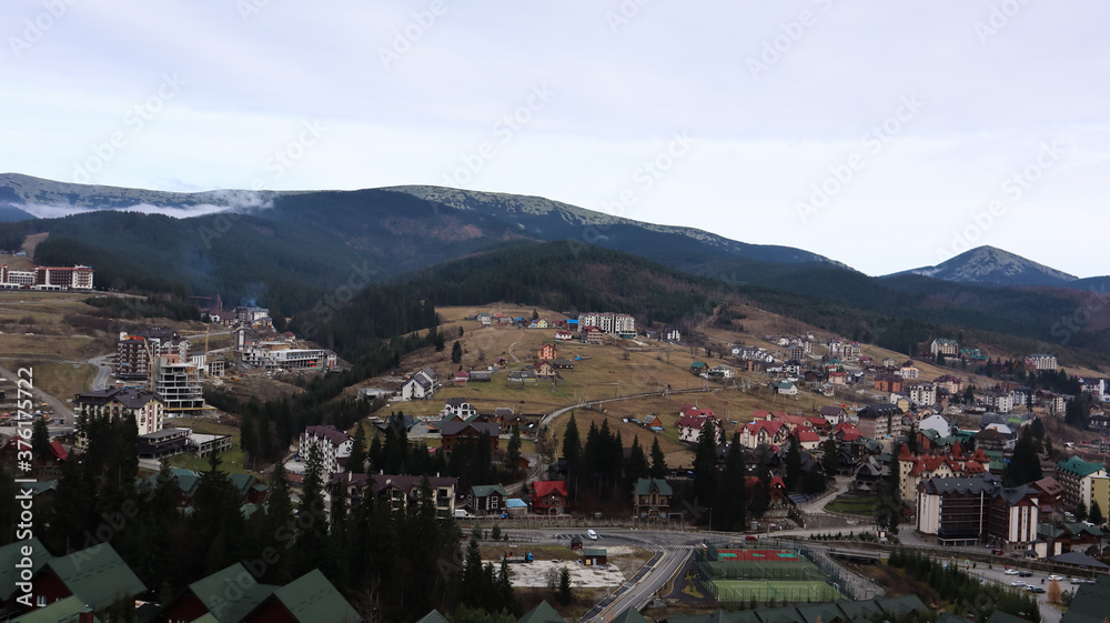 Bukovel ski resort in autumn aerial view. View of hotel houses in the ecological countryside against the background of spruce trees and mountain hills.