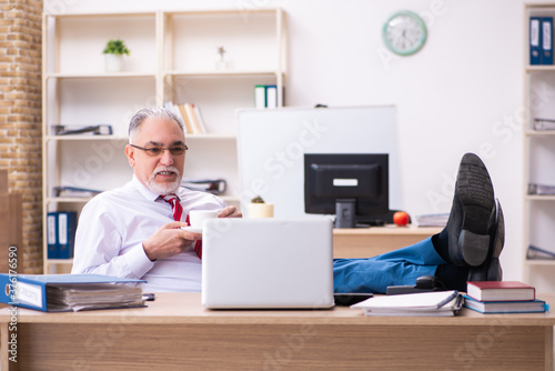 Old male employee enjoying coffee during coffee break © Elnur