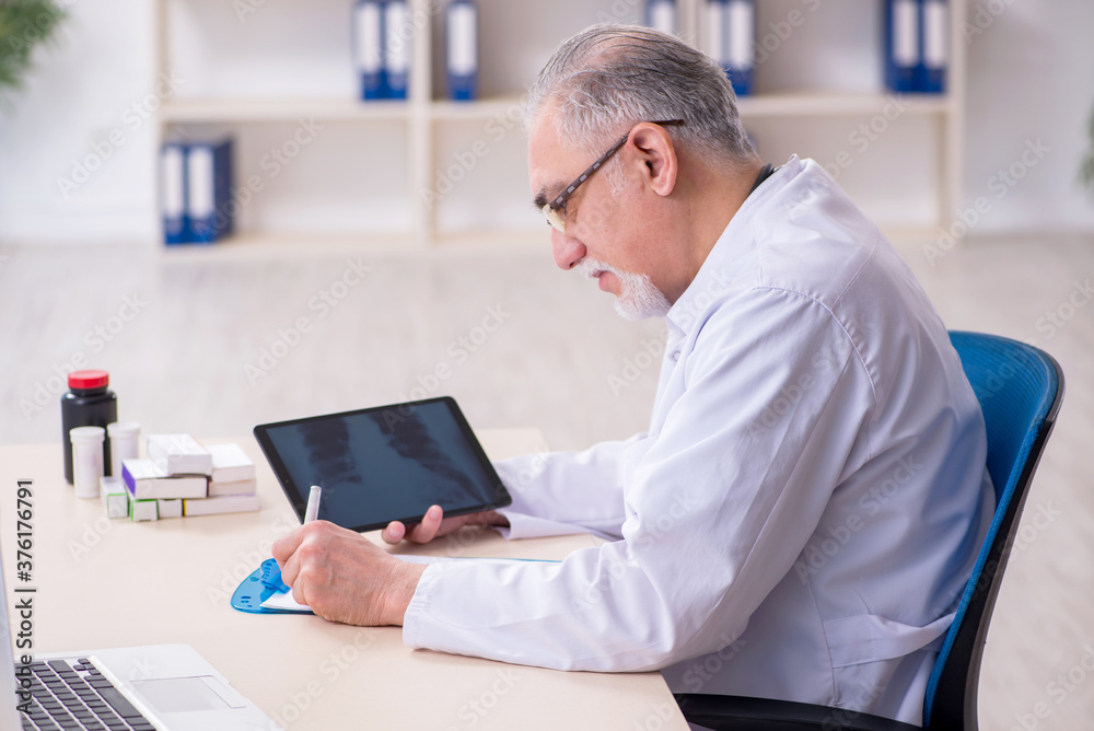 Old male doctor radiologist in telehealth concept Old male doctor radiologist in telehealth concept