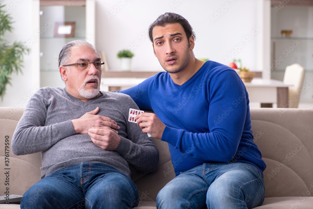 Young man looking after his sick father Young man looking after his sick father