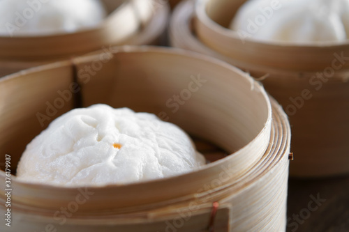 hot red pork steamed stuff bun or white bread with point in wooden basket for morning food or breakfast and dim sum snack at restaurant